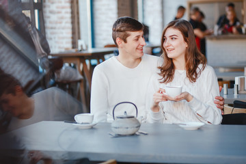 Pretty couple sitting in a cafe. Man and woman drinking a tea