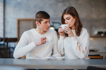 Pretty couple sitting in a cafe. Man and woman drinking a tea