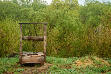 Beautiful old wooden well in the village in the background