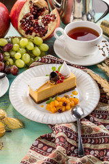 Square Earl Gray Rare Cheesecake With red berries and Cup of tea on blue wooden table