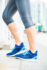 Woman slim sporty legs in bleu sneackers 