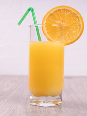  a glass with a straw decorated with a slice of orange on a light background