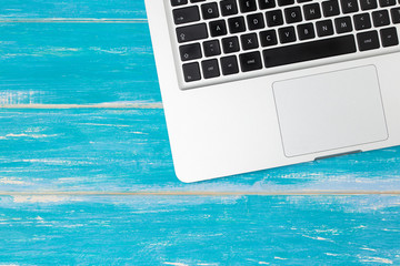 Top view of silver laptop / notebook on wooden table with copy space