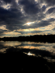 Summer evening on the pond with beautiful clouds sunset and their reflection in the water