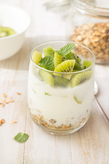 Obraz na płótnie Canvas Yogurt, granola and kiwi in glass