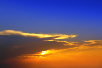 Beautiful cloudscape of colorful sunset sky with shining sun