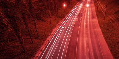 Red toned night with car light streaks. Night light painting stripes. Long exposure photography.