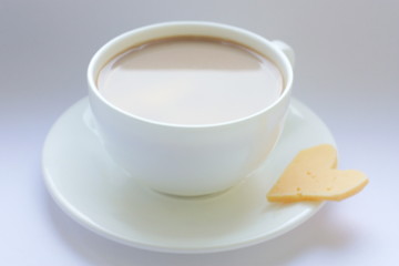  White porcelain cup. Coffee with milk. A cup on the window and a slice of cheese. Love. Morning.