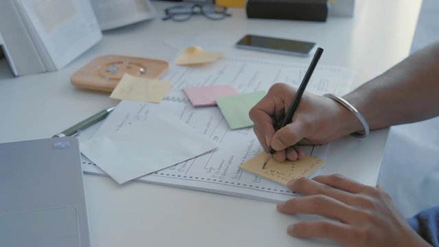 Close-Up Indian Student Hands Writing Cheat Sheet for Exam