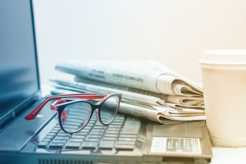 The concept of news. Newspaper, laptop, glasses on your desktop Coffee break.