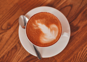 A cup of cappuccino on a wooden table