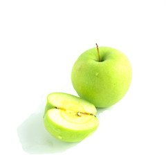 One whole and one half green apples isolated on white background.