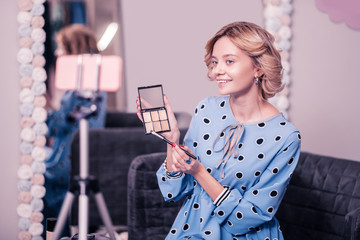Beauty blogger smiling while filming blog about top cosmetics