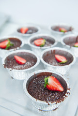chocolate cupcakes with icing and fresh strawberry tasty on white background