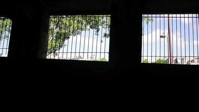 View from Parisian Metro Train RER of the dark tunnel with light stripes and security fences on top of tunnel view of rooftops of Paris through fences