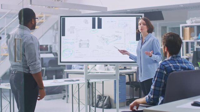 In the In Industrial Design Facility Team of Engineers and Technicians have a Meeting, Female Specialist Leads Briefing, Talks and Draws on Digital Interactive Whiteboard with Car Prototype Concepts