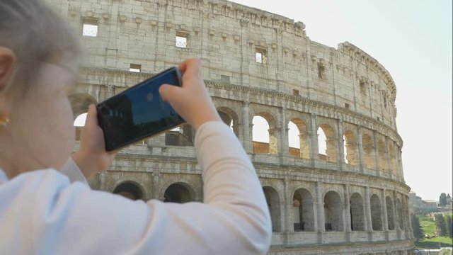 Cute little girl with parents takes photos of city sights, family trip to Rome