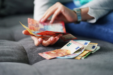 Woman counting euro and CHF banknotes salary family budget savings