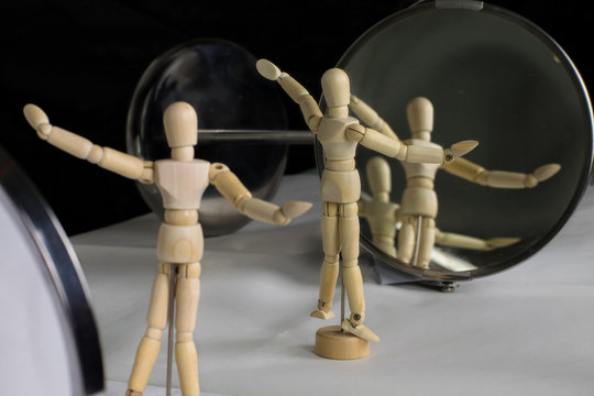 Mannequin in plastic pose in front of the mirror performs gymnastic exercises - still life