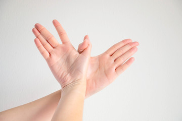 Woman posturing two hands to be bird shape; symbol of freedom.
