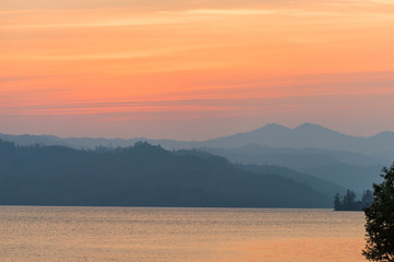 Hazy mountains behind a lake at sunset