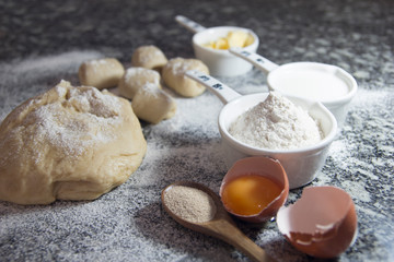 Making bread rolls background. Flour, egg, butter on granite. Selective focus.