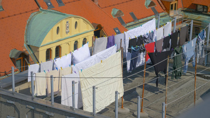 DRONE: Flying above clotheslines full of laundry set on a rooftop in Ljubljana.