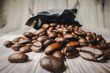 Roasted coffee beans against wooden background