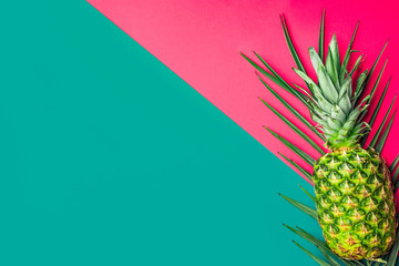 Ripe pineapple on green palm leaf on duotone fuchsia pink turquoise background. Trendy funky style...