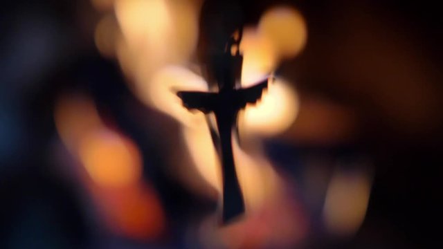 Blurred Crucifix Silhouette on Fire Flames Dark Background Slow Motion