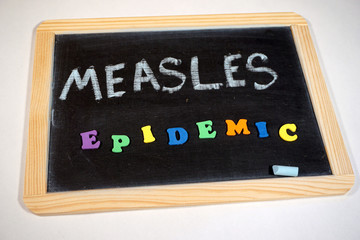 Fototapeta na wymiar Measles epidemic message on chalkboard