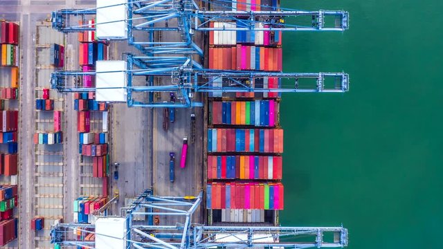 4k Hyper lapse aerial view container cargo ship loading and unloading in deep sea port, Aerial top view of logistic import export transportation business by container ship in open sea.