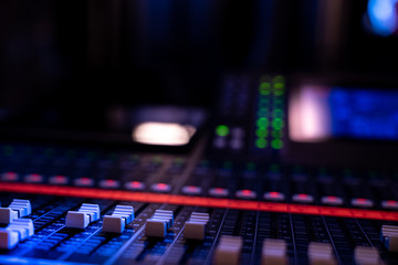 Close up of faders on an audio mixing console in a concert venue