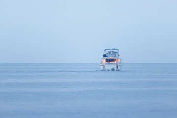 yacht in the blue sea  at the blue hour electric lighting on board, a luxury lifestyle scene
