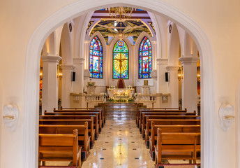 Interior view of beautiful colorful church with empty pews and warm light.