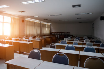 Fototapeta na wymiar Education concept: Empty college or university classroom with wooden tables and chairs in row without student or teacher in the room. School classroom with window opened, clean and tidy ready for new 
