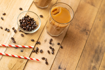 Iced coffee in transparent glasses with ice and straws, on a wooden background, a refreshing drink, refreshing, summer mood, with copy space