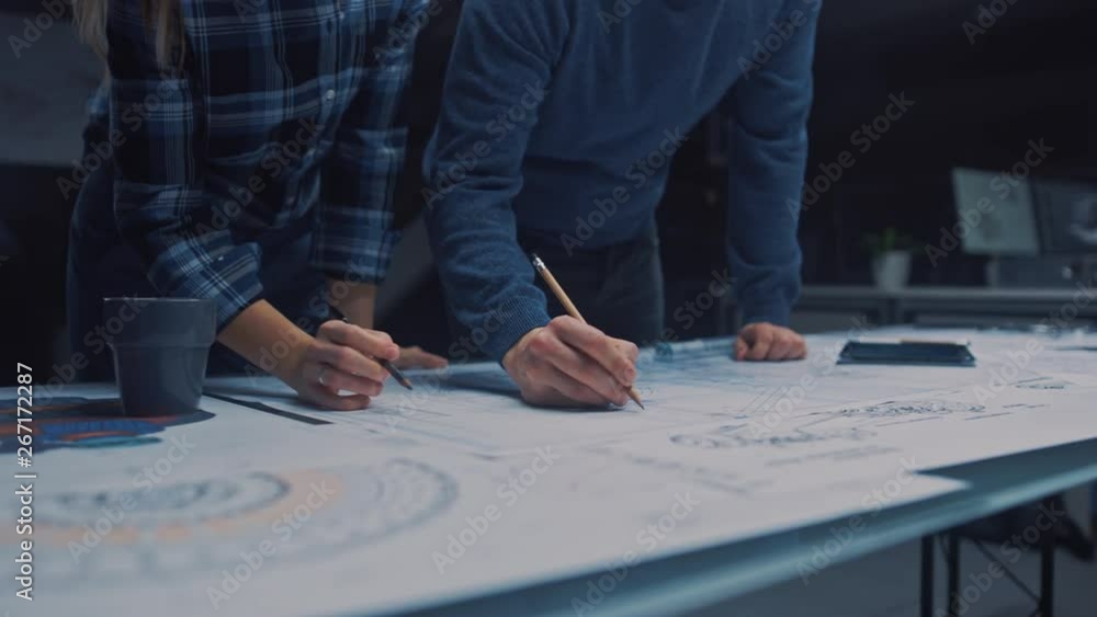 Poster male and female engineers talk and work on a blueprints using digital tablet and conference table. i