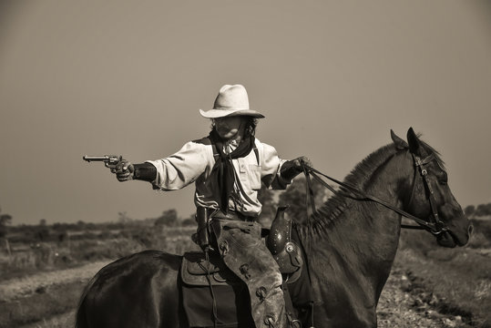 Vintage image of cowboy Showing horse riding, and shooting guns
