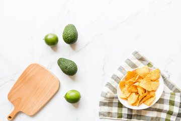 Fresh avocado, lime lying on marble background. Recipe for Cinco de Mayo party. Top view, overhead, flat lay, copy space