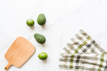 Fresh avocado, lime lying on marble background. Recipe for Cinco de Mayo party. Top view, overhead,...