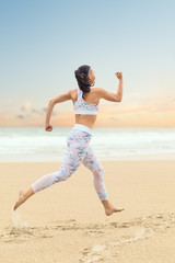 Fototapeta na wymiar Young athlete woman jogging on the sea beach