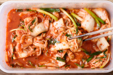 Kimchi cabbage in the plastic box with chopsticks, Korean food