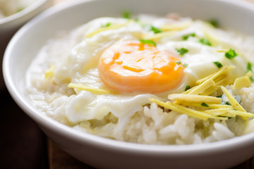 Thai rice soup or soft-boiled rice with pork and egg in the bowl