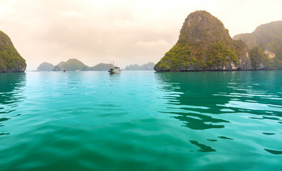 Beautiful Tourist cruise ship floating among limestone rocks at Ha Long Bay. This is the UNESCO World Heritage Site, it is a beautiful natural wonder in northern Vietnam