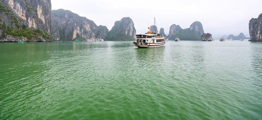 Beautiful Tourist cruise ship floating among limestone rocks at Ha Long Bay. This is the UNESCO World Heritage Site, it is a beautiful natural wonder in northern Vietnam