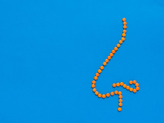 Nose of orange pills on a blue background. The concept of treatment of diseases of the nose and allergies. Flat lay.