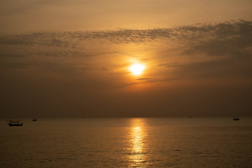 Fototapeta na wymiar view of sunrise over the sea with fisheries boats