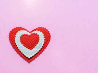 Bright red and white heart on light pink background. The view from the top. Flat lay.