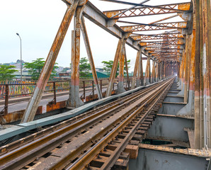 Vintage railroad tracks leading over the famous Long Bien Bridge, Hanoi, Vietnam. This is the...